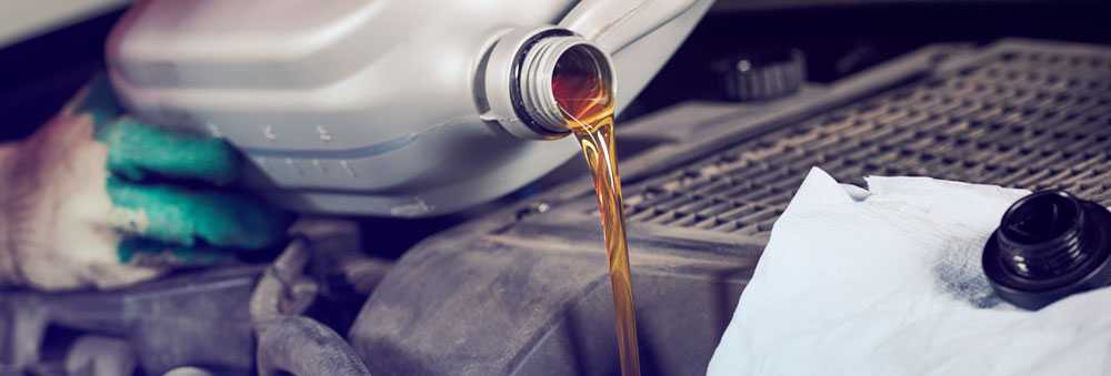 A Technician Pouring Oil Into An Engine During Car Servicing Southall